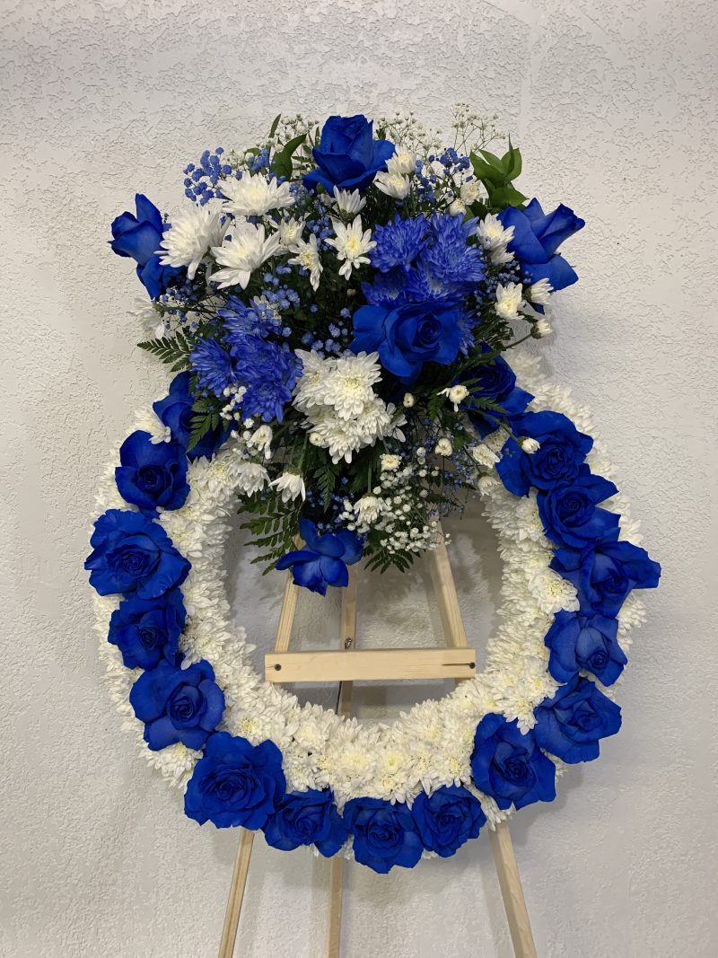 Blue roses, white pampas, baby breath standing funeral arrangement